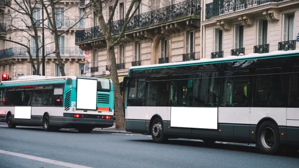Two Buses on a street, somewhere in a city in France.