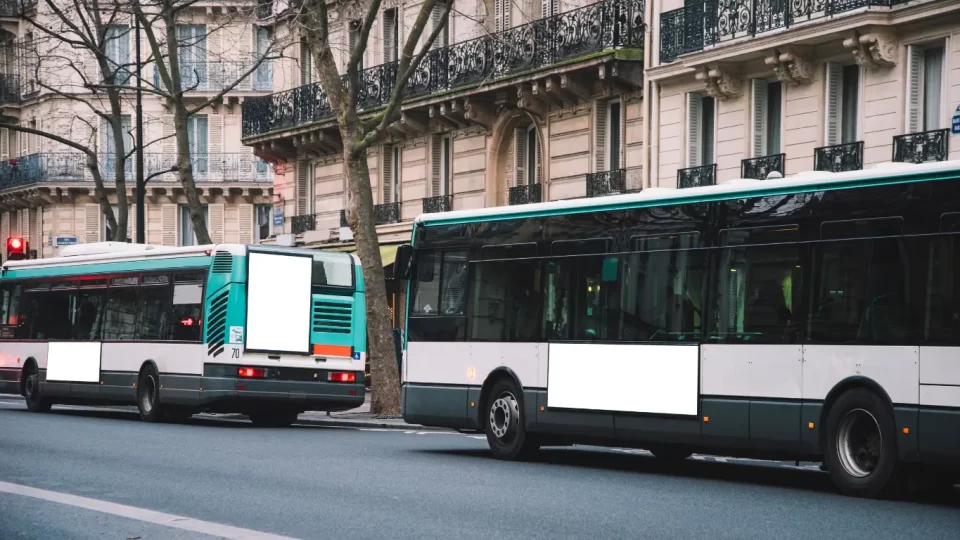 Two Buses on a street, somewhere in a city in France.